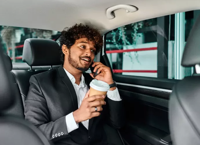 curly-haired-businessman-discusing in vehicle